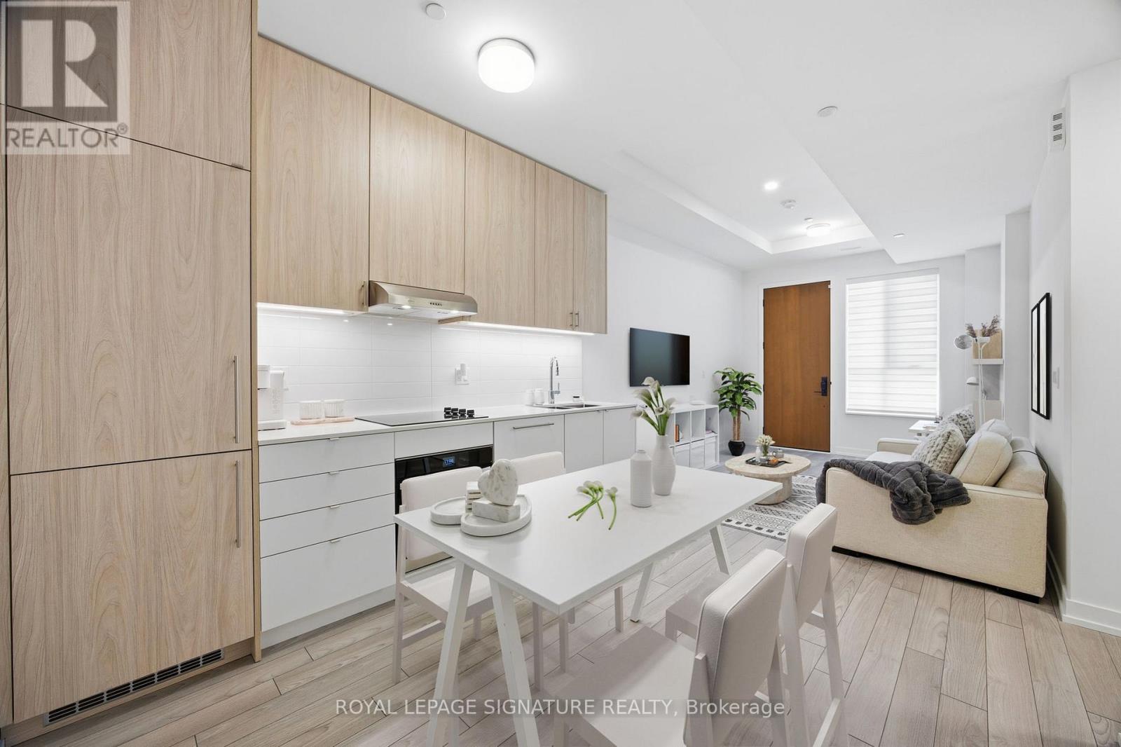 A well-lit, modern kitchen with wooden cabinets and a dining table set for two.