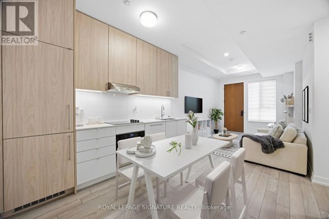A well-lit, modern kitchen with wooden cabinets and a dining table set for two.