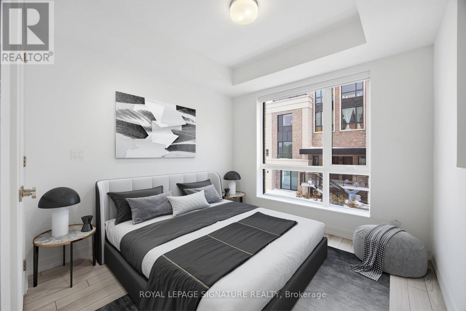A bedroom with a large bed and a window overlooking a cityscape.