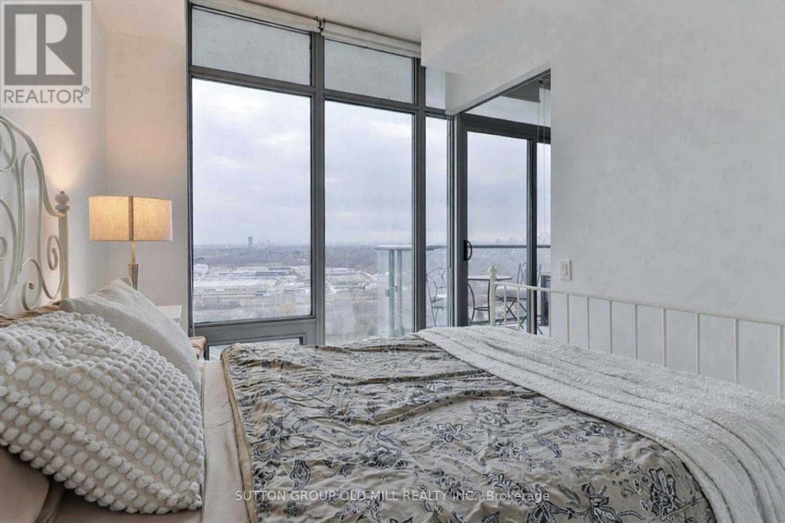 A bedroom with a large bed and a view of the ocean through the windows.