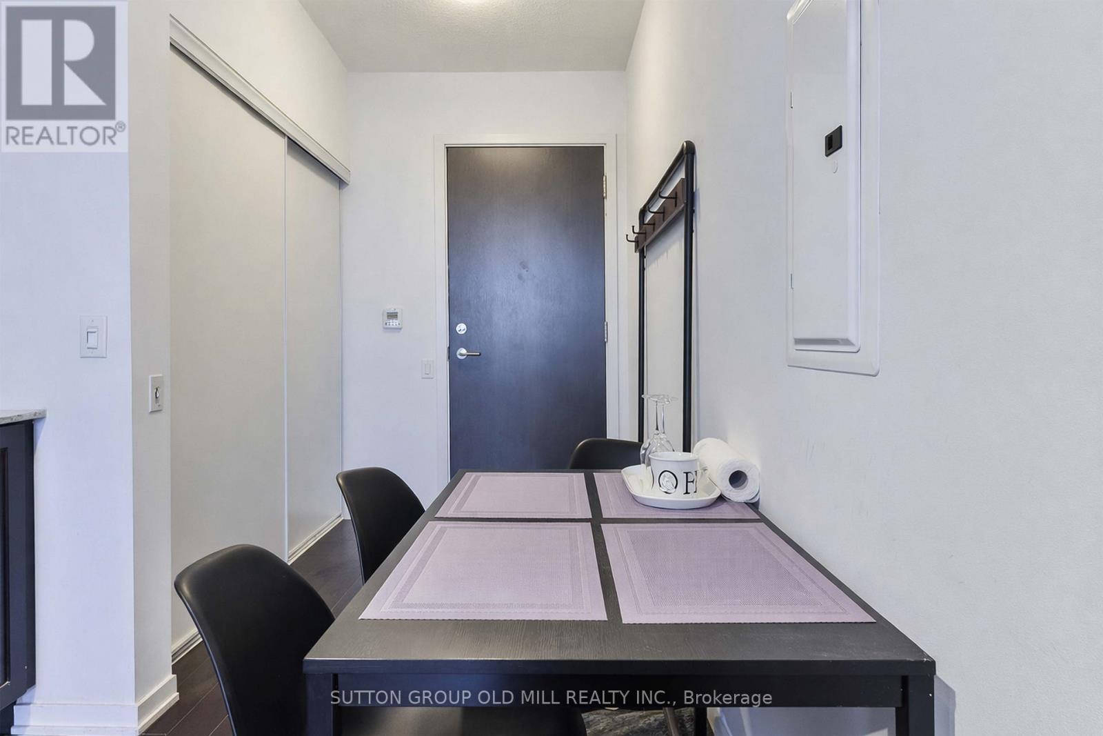 A dining room with a table and chairs and a door.