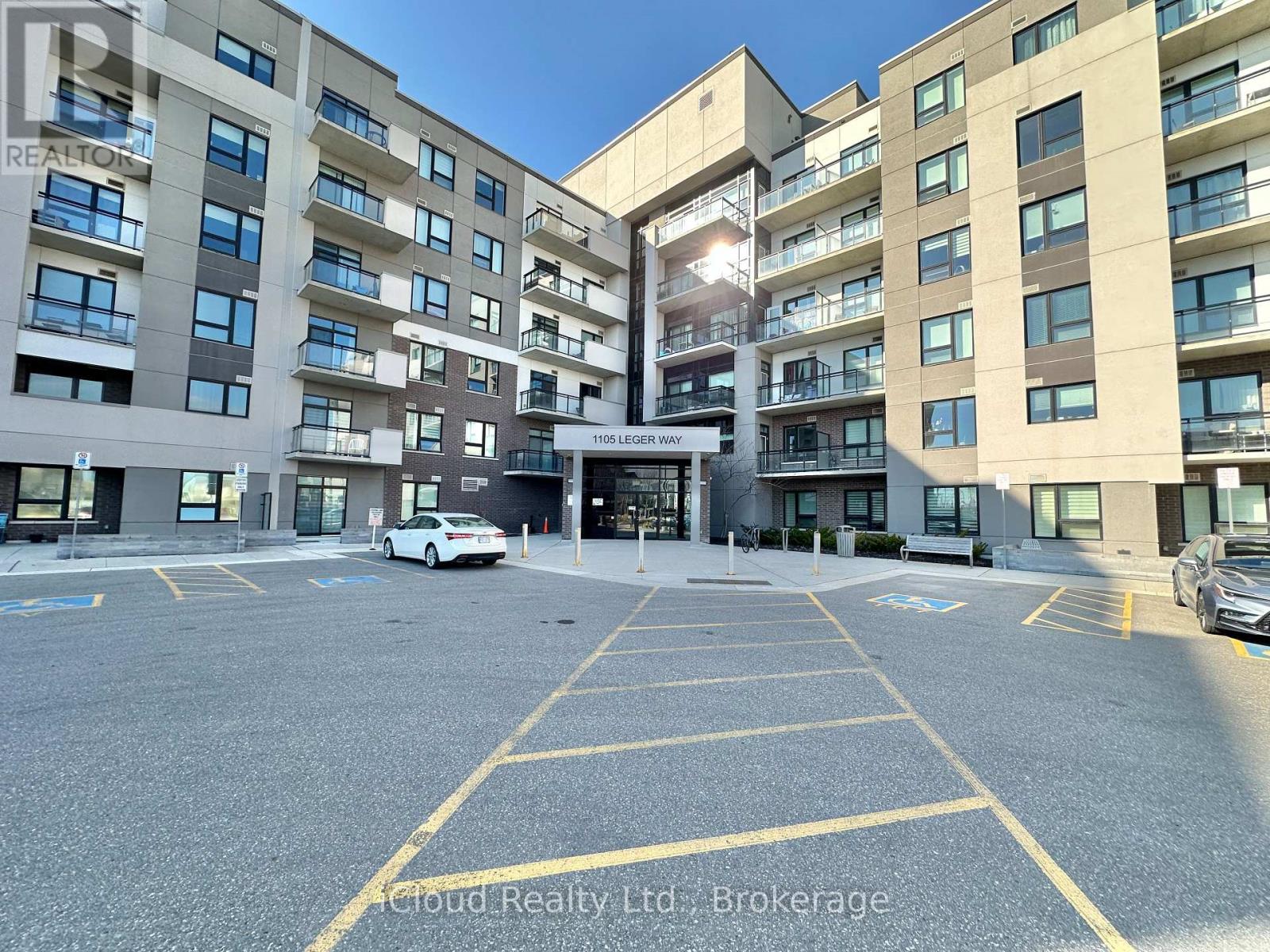 A parking lot in front of a multi-story residential building.