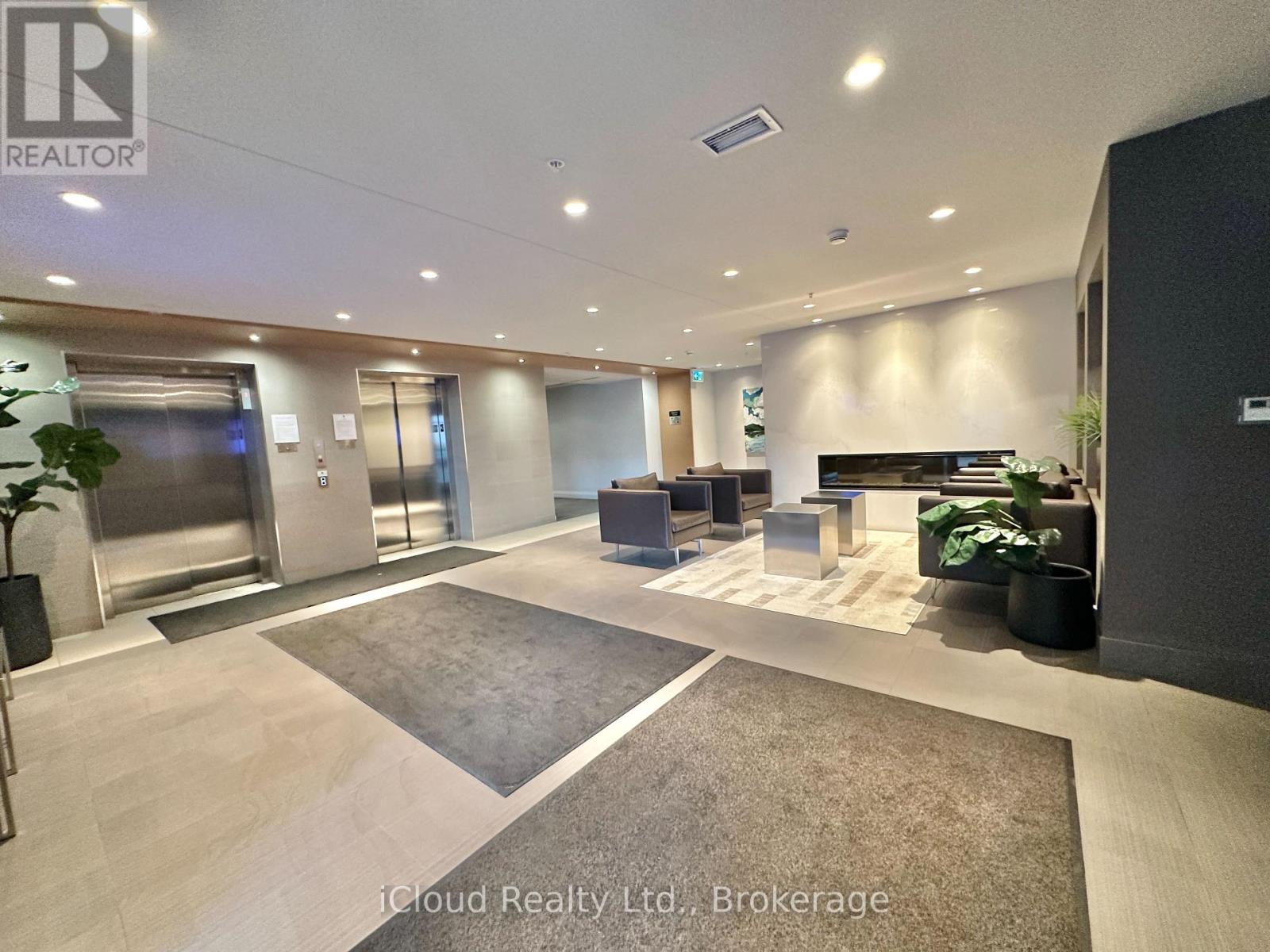 A spacious office lobby with a reception desk and a large rug.