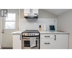 A white kitchen with a black stove top oven.