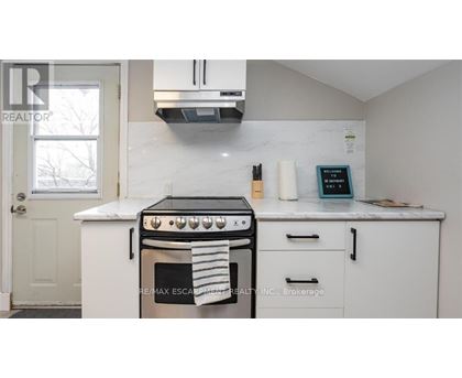 A white kitchen with a black stove top oven.