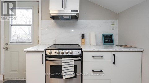 A white kitchen with a black stove top oven.
