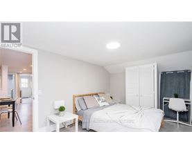 A bedroom with a bed, nightstand, and chair.
