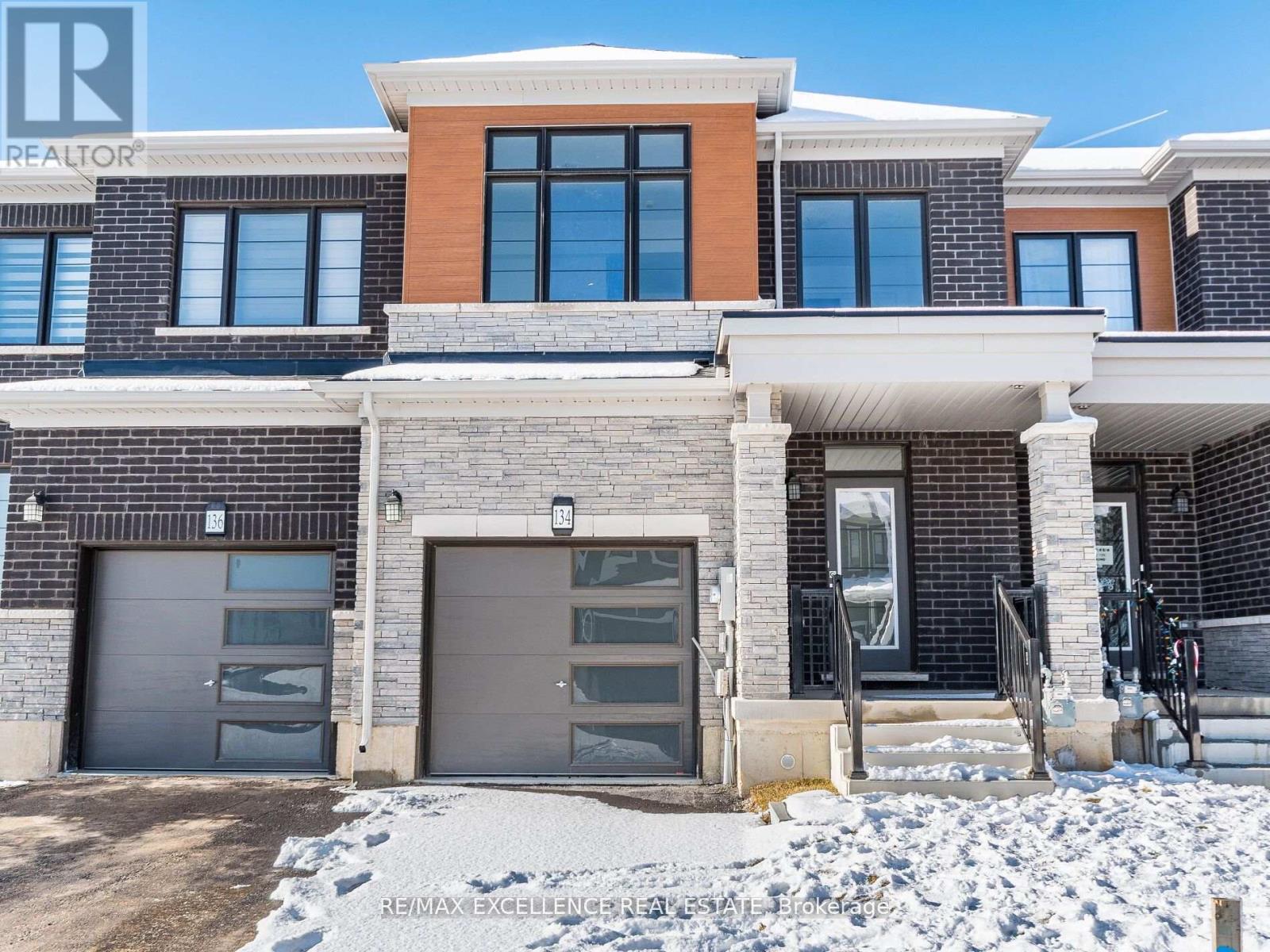 A modern house with a garage and a driveway in front.