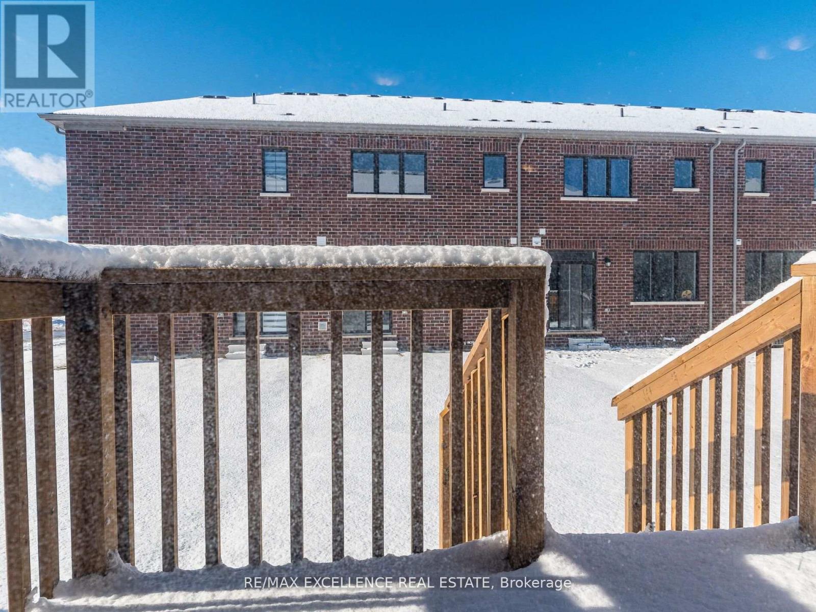 A snow-covered building with a wooden fence in front.