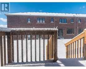 A snow-covered building with a wooden fence in front.