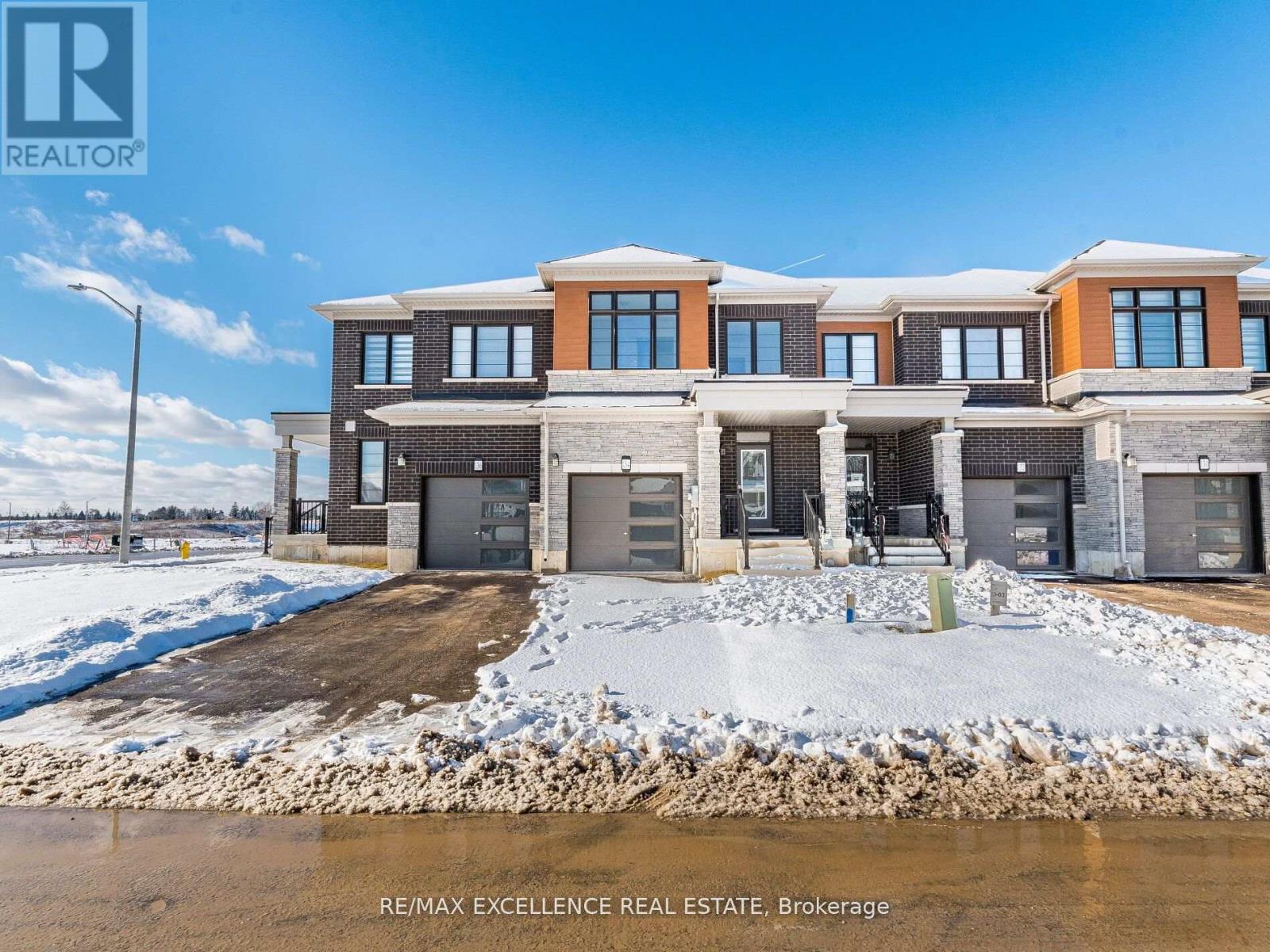 A large, modern house with a snow-covered ground in front.