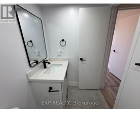 A bathroom with a sink, mirror, and a door.