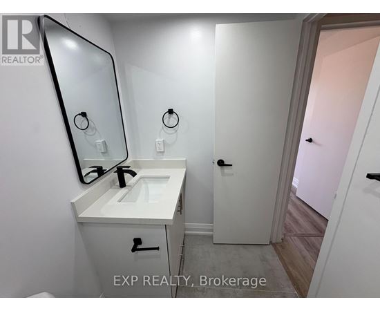 A bathroom with a sink, mirror, and a door.