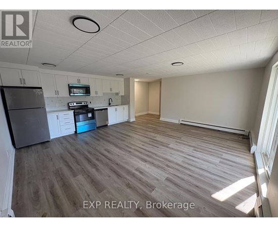 A kitchen with a refrigerator, oven, and microwave.