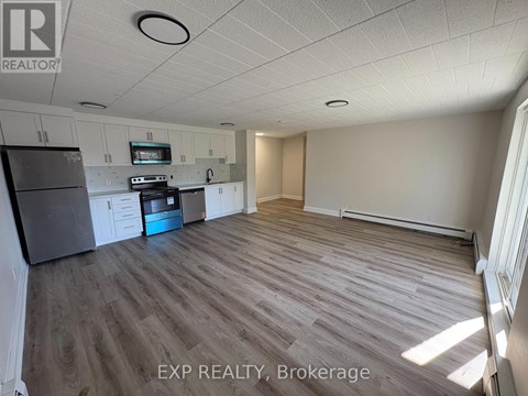 A kitchen with a refrigerator, oven, and microwave.