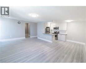 A spacious living room with a kitchenette in the background.