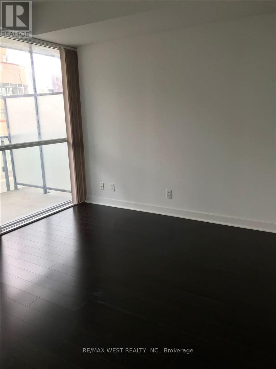 A room with a large window and a wooden floor.