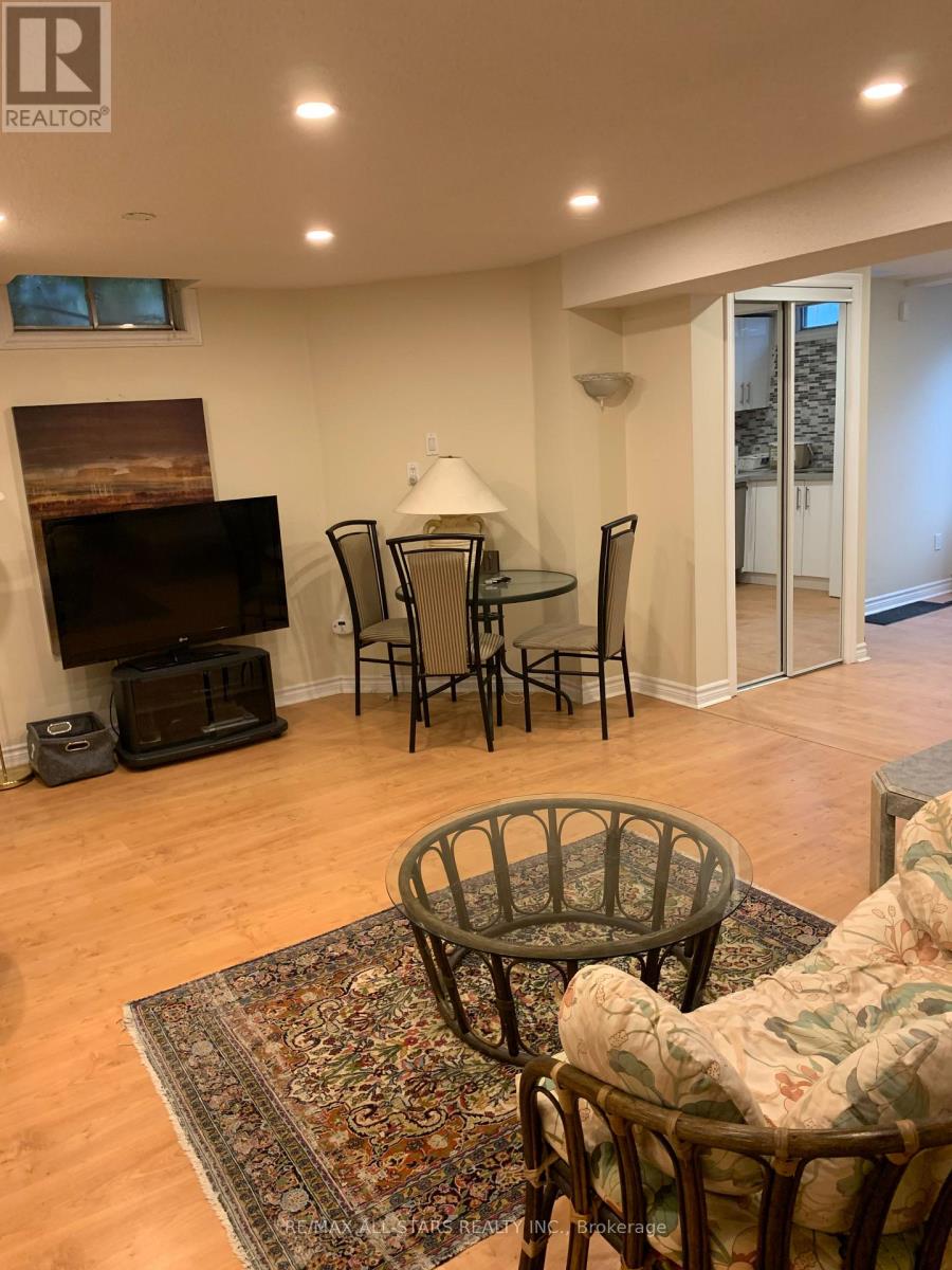 A living room with a fireplace, chairs, and a rug.