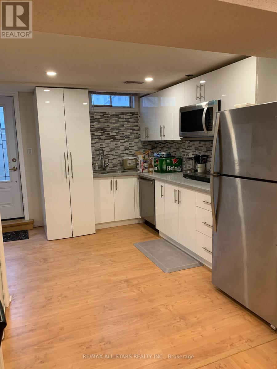 A kitchen with a refrigerator, cabinets, and a countertop.