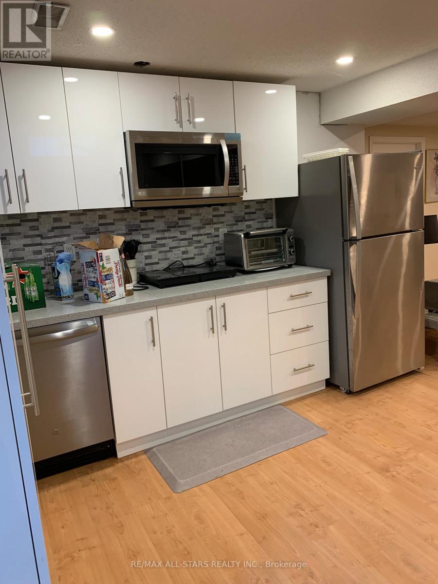 A kitchen with white cabinets and a stainless steel refrigerator.