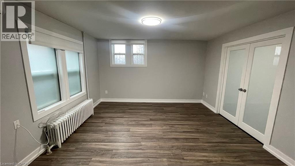 A room with wooden flooring and a window with a white frame.