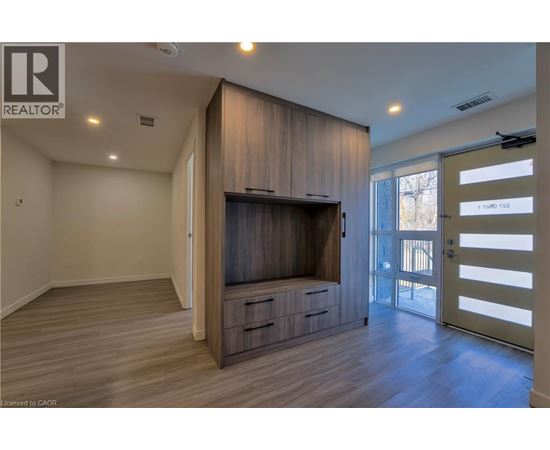 A living room with a television and wooden cabinets.