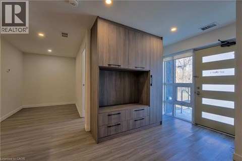 A living room with a television and wooden cabinets.