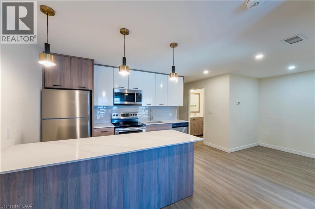 A modern kitchen with a blue countertop and stainless steel appliances.