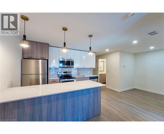 A modern kitchen with a blue countertop and stainless steel appliances.