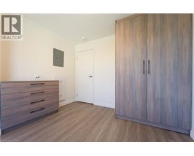A bedroom with a wooden floor and a large wardrobe.