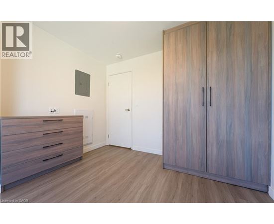 A bedroom with a wooden floor and a large wardrobe.