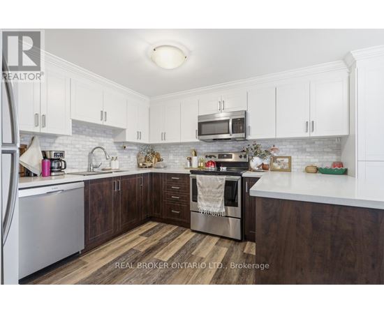 A kitchen with white cabinets and a wooden floor.