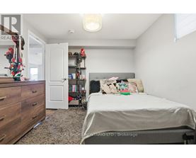 A bedroom with a bed, dresser, and bookshelf.