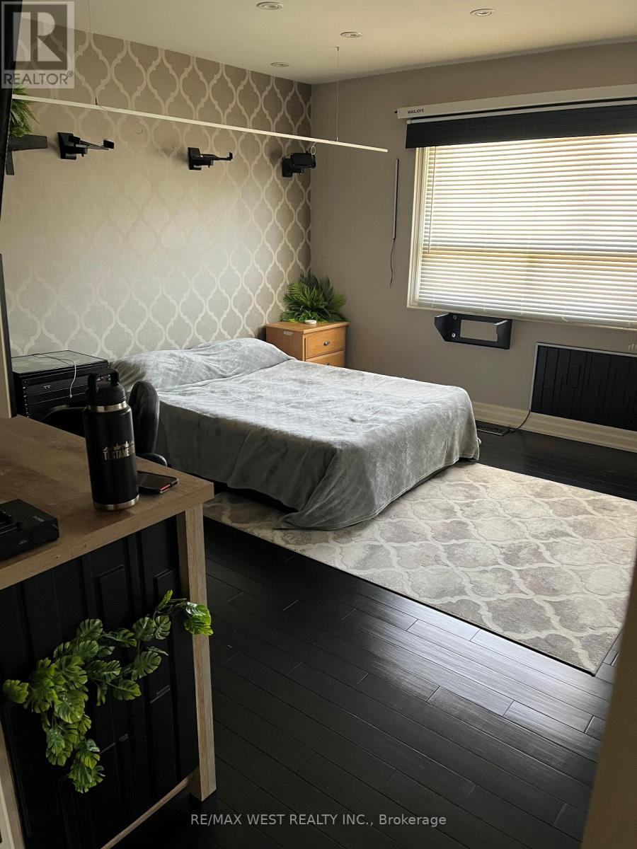 A bedroom with a bed, a desk, and a window.