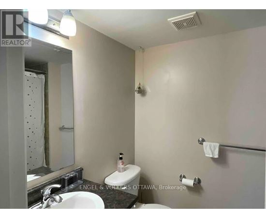 A bathroom with a toilet, sink, and mirror.