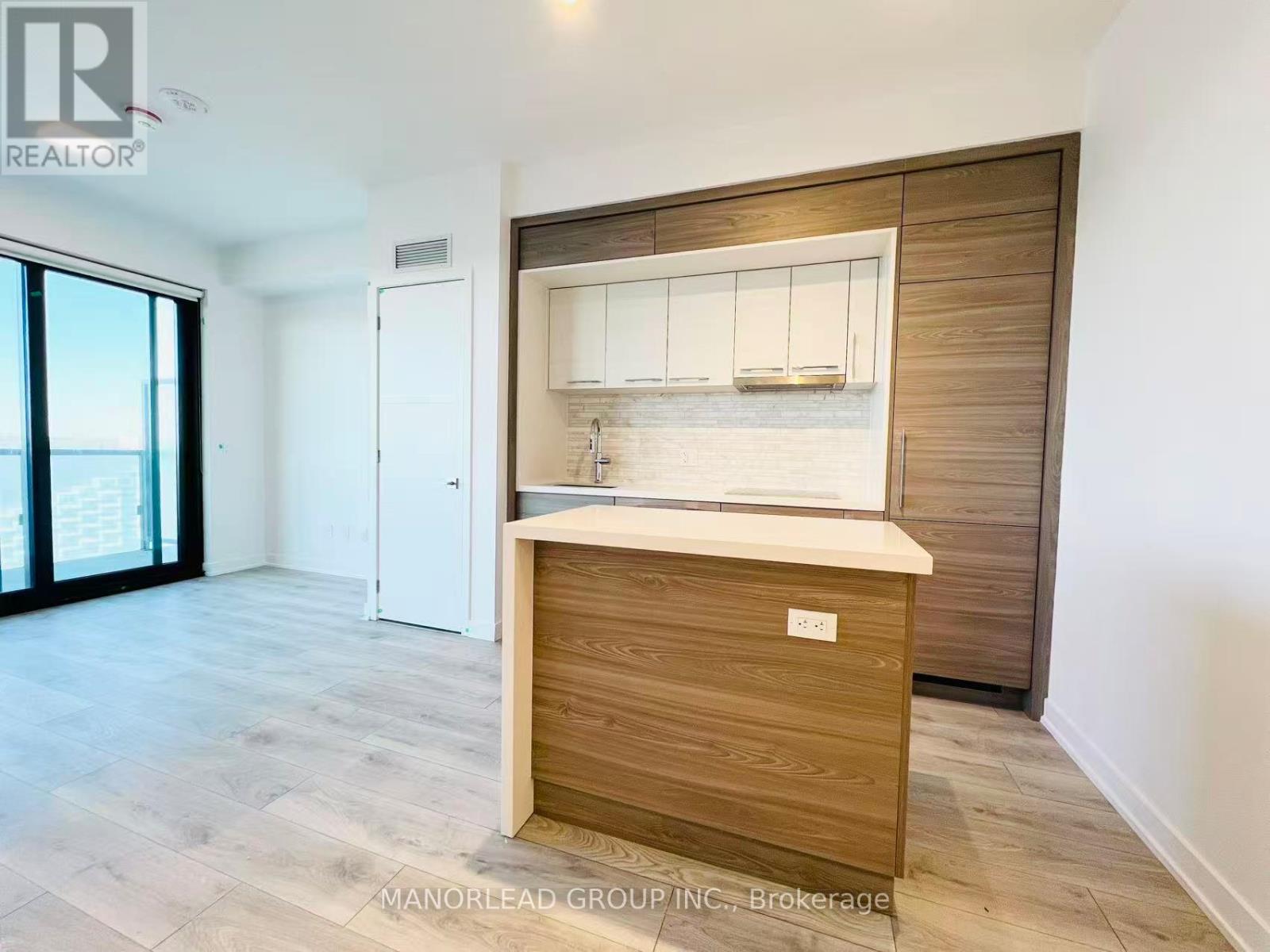 A kitchen area with a wooden island and white cabinets.