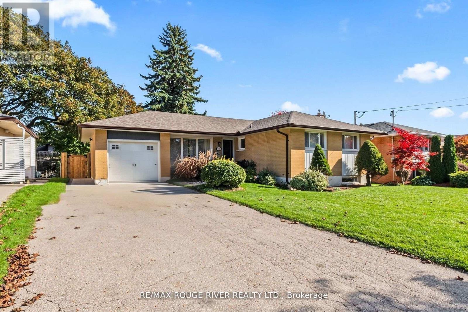 A house with a brown roof and a white garage door is for sale.