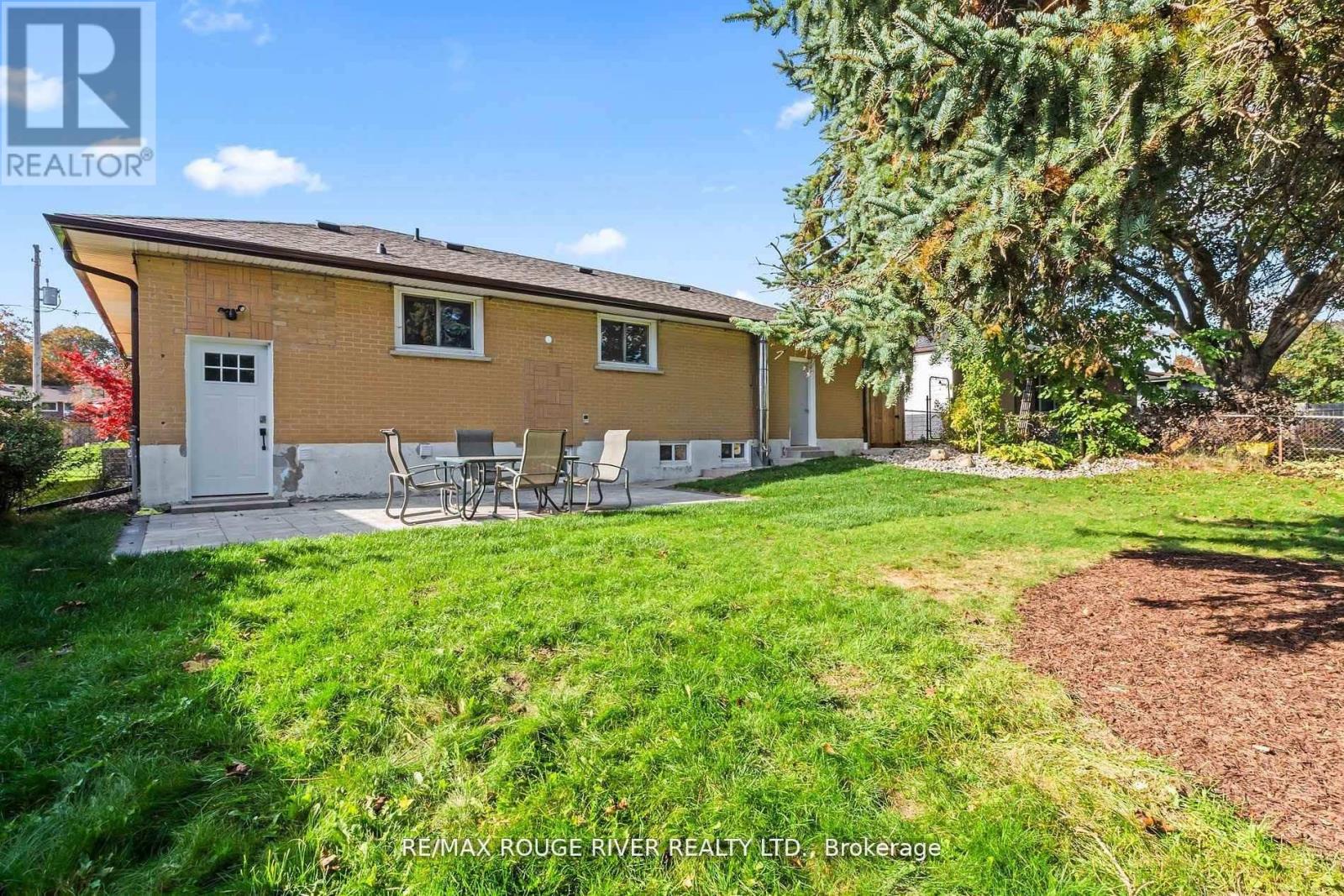 A house with a lawn and a tree in front of it.