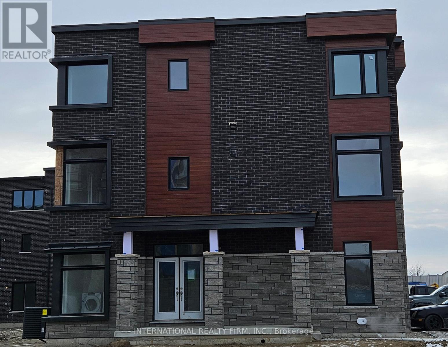 A modern two-story building with a brick facade and large windows.