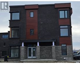 A modern two-story building with a brick facade and large windows.
