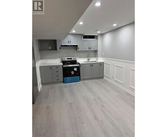 A kitchen with grey cabinets and a blue box on the counter.