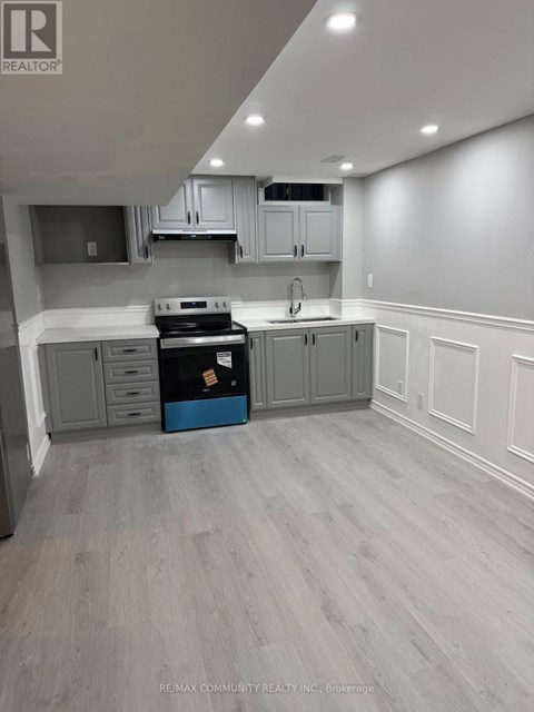 A kitchen with grey cabinets and a blue box on the counter.