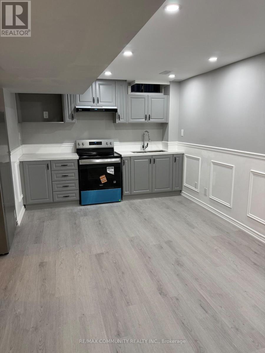 A kitchen with grey cabinets and a black stove top oven.