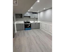 A kitchen with grey cabinets and a black stove top oven.