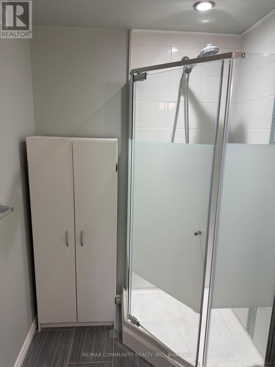 A bathroom with a glass shower door and a glass-enclosed shower stall.