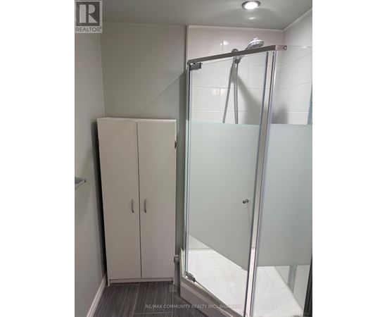 A bathroom with a glass shower door and a glass-enclosed shower stall.