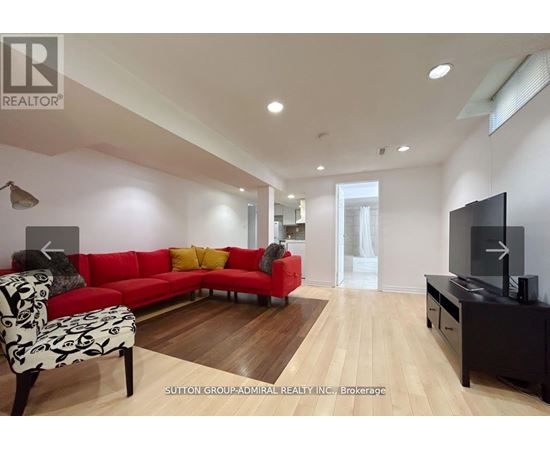 A living room with a red couch and a television.