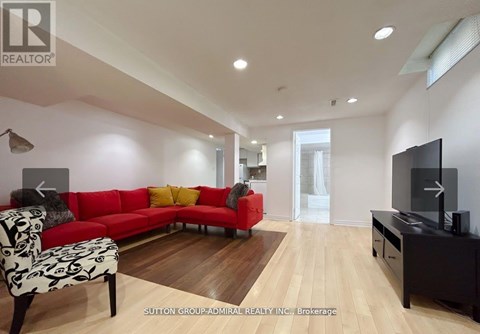 A living room with a red couch and a television.