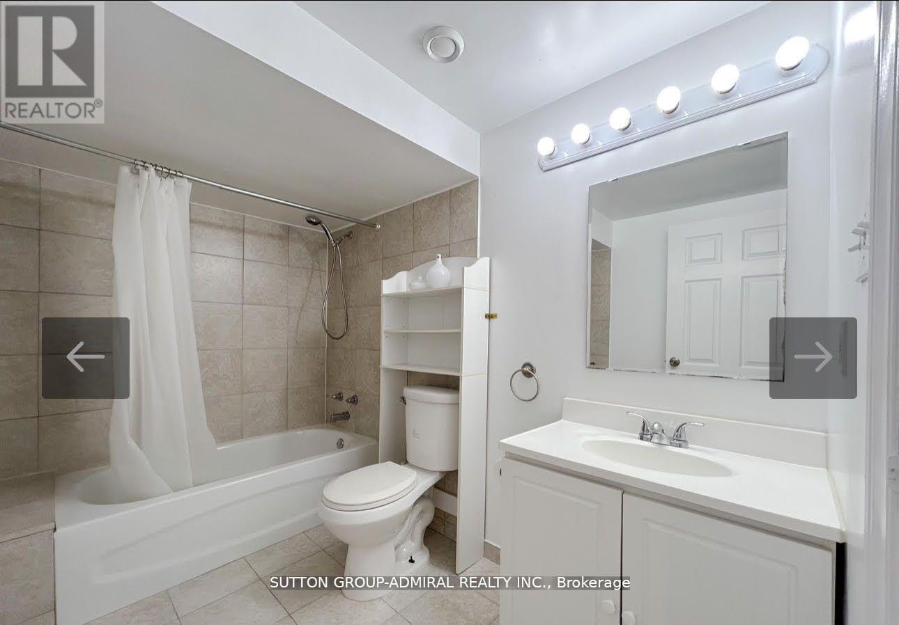 A white bathroom with a tub, toilet, and sink.