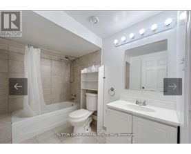 A white bathroom with a tub, toilet, and sink.
